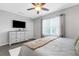 Bright, cozy bedroom with a dresser and TV, window, and ceiling fan at 6516 Serenity Fall Ln, Sarasota, FL 34240