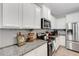 Modern kitchen boasts white cabinets, stainless steel appliances, and granite countertops at 6516 Serenity Fall Ln, Sarasota, FL 34240