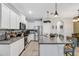 Modern kitchen featuring stainless steel appliances, granite countertops, white cabinetry, and a spacious island at 6516 Serenity Fall Ln, Sarasota, FL 34240