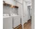 Well-lit laundry room with washer, dryer, and storage shelves for convenience at 6516 Serenity Fall Ln, Sarasota, FL 34240