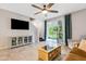 Modern living room featuring a large entertainment center and access to the outdoor patio through sliding doors at 6516 Serenity Fall Ln, Sarasota, FL 34240