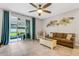 Bright living room with a ceiling fan and sliding door access to the outdoor patio at 6516 Serenity Fall Ln, Sarasota, FL 34240