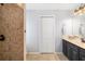 Bathroom with dark vanity and shower with stone-look tiling at 7209 35Th E St, Sarasota, FL 34243