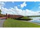 Scenic view of the community with wooden bridge over a lake, set against a backdrop of lush greenery and a clear sky at 7209 35Th E St, Sarasota, FL 34243