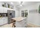 Modern kitchen featuring white cabinets, stainless steel appliances, granite island and tile flooring at 7209 35Th E St, Sarasota, FL 34243