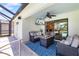 Relaxing outdoor patio with comfortable seating, ceiling fan, television, and access to the pool area at 7209 35Th E St, Sarasota, FL 34243