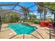 Inviting screened-in pool with spa, patio seating, and lush tropical surroundings for ultimate outdoor living at 7209 35Th E St, Sarasota, FL 34243