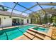 Inviting screened-in pool and spa area with plenty of seating and tropical landscaping at 7209 35Th E St, Sarasota, FL 34243