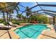 Sparkling screened-in pool with sun loungers, spa, and lush tropical landscaping perfect for relaxation at 7209 35Th E St, Sarasota, FL 34243