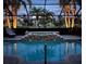 Screened-in pool area with jacuzzi, palm trees, and lush landscaping, perfect for evening relaxation and outdoor enjoyment at 7209 35Th E St, Sarasota, FL 34243