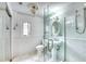 Bright bathroom with marble floors, glass shower door, and pedestal sink at 76 S Washington Dr, Sarasota, FL 34236
