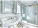 Bathroom featuring white marble walls, pedestal sink, and glass enclosed shower at 76 S Washington Dr, Sarasota, FL 34236