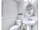 Classic white bathroom with pedestal sink, subway tile, and decorative oval mirror at 76 S Washington Dr, Sarasota, FL 34236