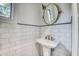 Classic bathroom features pedestal sink, subway tile walls and an oval decorative mirror at 76 S Washington Dr, Sarasota, FL 34236