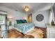 White bedroom featuring hardwood floors, queen size bed with patterned comforter, side table and ornate wall decoration at 76 S Washington Dr, Sarasota, FL 34236