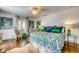 Bright bedroom featuring hardwood floors, white walls, and a comfortable queen size bed with colorful patterned comforter at 76 S Washington Dr, Sarasota, FL 34236