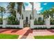 Charming two-story home with a black metal fence and a beautiful array of mature palm trees at 76 S Washington Dr, Sarasota, FL 34236