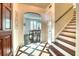 Charming foyer featuring decorative tile flooring, staircase, and a glimpse into the dining room at 76 S Washington Dr, Sarasota, FL 34236