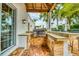 Outdoor kitchen featuring a built-in grill, counter space, and wooden cabinetry, perfect for outdoor dining and entertaining at 76 S Washington Dr, Sarasota, FL 34236