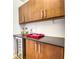 Pantry featuring wood cabinets with modern chrome hardware, wine cooler and ample storage space at 76 S Washington Dr, Sarasota, FL 34236