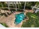 Aerial view of a private pool with a unique shape, surrounded by brick patio, lush greenery, and lounge chairs at 76 S Washington Dr, Sarasota, FL 34236