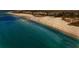 Breathtaking aerial view showcasing pristine white sand beach, shimmering turquoise ocean, and beachfront property at 777 Beach Rd # 1B, Sarasota, FL 34242