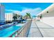 Balcony overlooking community pool area with views of tropical landscaping and building exterior, providing a serene outdoor space at 777 Beach Rd # 1B, Sarasota, FL 34242