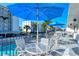 Balcony sitting area with tables, chairs, and blue umbrellas overlooking the pool area of this well-maintained property at 777 Beach Rd # 1B, Sarasota, FL 34242