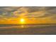 Golden hour photo of a beach with waves, sand, and a flock of birds flying over the tranquil ocean at 777 Beach Rd # 1B, Sarasota, FL 34242