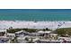 Panoramic view of a sandy beach with turquoise water, buildings, and sunbathers at 777 Beach Rd # 1B, Sarasota, FL 34242