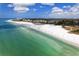 Aerial view of a stunning beach with white sand, turquoise waters, and a beachfront condo at 777 Beach Rd # 1B, Sarasota, FL 34242