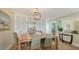 The dining room features a wooden table, six chairs, shuttered walls and a stylish chandelier at 777 Beach Rd # 1B, Sarasota, FL 34242