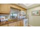 Kitchen with countertop, white appliances, wood cabinets and a pass-through to the living space at 777 Beach Rd # 1B, Sarasota, FL 34242