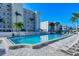 Exterior shot of a spacious pool area surrounded by lounge chairs and tropical landscaping at 777 Beach Rd # 1B, Sarasota, FL 34242