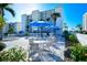 Relaxing pool area with lounge chairs, tables with blue umbrellas, and tropical landscaping for a resort-style experience at 777 Beach Rd # 1B, Sarasota, FL 34242