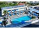 An aerial view of a pool surrounded by lounge chairs and balconies with blue umbrellas at 777 Beach Rd # 1B, Sarasota, FL 34242