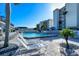 Resort-style pool area with lounge chairs, pavers, palm trees, and well-maintained landscaping, creating a tranquil setting at 777 Beach Rd # 1B, Sarasota, FL 34242