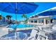 Beautiful pool area featuring tables, chairs, umbrellas, and tropical landscaping at 777 Beach Rd # 1B, Sarasota, FL 34242