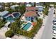Real estate aerial view showing the house with a pool, solar panels, and lush greenery at 803 Gladiolus St, Anna Maria, FL 34216