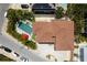 Aerial view of a home with a rectangular pool, hot tub, lounge chairs, and a red umbrella at 803 Gladiolus St, Anna Maria, FL 34216