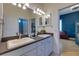 Bright bathroom features double sinks, dark countertops, mirrors, and access to a bedroom at 803 Gladiolus St, Anna Maria, FL 34216