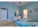 Bright bedroom featuring light blue walls, light floors, bed, furniture, and ensuite bathroom access at 803 Gladiolus St, Anna Maria, FL 34216