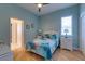 Well-lit bedroom boasts a ceiling fan, light blue walls, a bright bedspread, and well-placed lamps at 803 Gladiolus St, Anna Maria, FL 34216