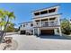 A beautiful raised beach house with a three-story design boasts multiple decks and a spacious paved driveway at 803 Gladiolus St, Anna Maria, FL 34216