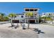 Exterior elevation featuring a lovely home, palm trees, a driveway, and a staircase at 803 Gladiolus St, Anna Maria, FL 34216