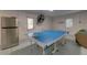 A bright game room features a ping pong table, a refrigerator, and durable speckled floors at 803 Gladiolus St, Anna Maria, FL 34216