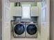 Laundry room with modern appliances and dual-door access at 803 Gladiolus St, Anna Maria, FL 34216