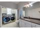 Laundry room with modern appliances, white cabinets, and a window for natural light at 803 Gladiolus St, Anna Maria, FL 34216