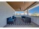Spacious covered patio showing wood ceiling, wicker furniture with blue cushions and black and white rug at 803 Gladiolus St, Anna Maria, FL 34216