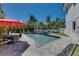 Backyard pool area surrounded by lush tropical landscaping, seating, and interlocking brick at 803 Gladiolus St, Anna Maria, FL 34216